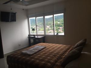 1 dormitorio con cama y ventana grande en Hotel Tijerinos en Boaco