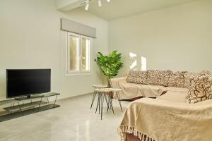 a living room with a couch and a flat screen tv at Mariñeiro Apartment! in Zakynthos Town