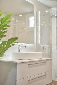 Baño blanco con lavabo y espejo en Mariñeiro Apartment!, en Zakynthos
