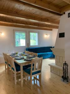 a dining room with a table and a blue couch at Domek Między Jeziorami in Wąglikowice
