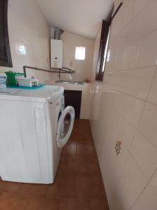 a small bathroom with a washing machine in it at Casa das Peleteiro Ribeira Sacra in Ourense