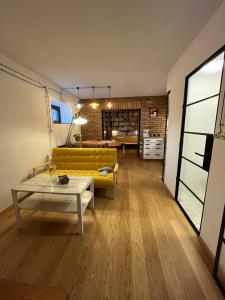 ein Wohnzimmer mit einem gelben Sofa und einem Tisch in der Unterkunft Bydlit cz in Brünn