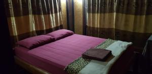 a bedroom with a purple bed with a purple pillow at Peace of Love Pai in Pai