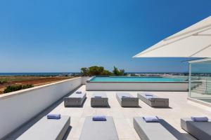eine Terrasse mit Stühlen, einem Sonnenschirm und einem Pool in der Unterkunft Perla Saracena Hotel & Restaurant in Salve