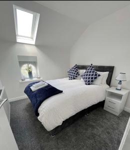 a bedroom with a large bed with pillows and a window at Ballycastle Town Centre Studio Apartment in Ballycastle