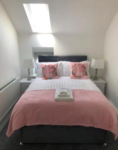 a bedroom with a large bed with a pink blanket at Ballycastle Town Centre Studio Apartment in Ballycastle