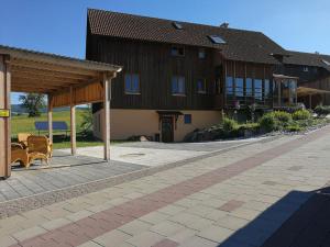 um edifício com um pavilhão e cadeiras em frente em Ferienwohnung Csilla 2 em Oberweid