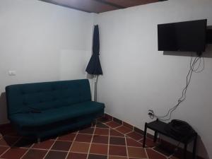 a living room with a green couch and a television at Casa de descanso en marinilla in Marinilla