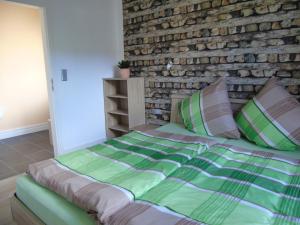 uma cama num quarto com uma parede de tijolos em Ferienwohnung Csilla 2 em Oberweid