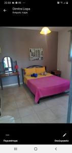 a bedroom with a large bed with a pink blanket at MUSSES in Stratoni