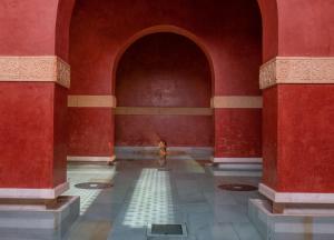 una persona caminando en una habitación con paredes rojas en Riad Medina Mudéjar Cádiz en Chiclana de la Frontera