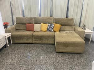un sofá marrón con almohadas en la sala de estar en COPA 4 QUARTOS ENTRE PRAIA E METRÔ m, en Río de Janeiro