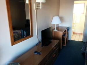 a hotel room with a television on a dresser with a mirror at Economy Inn Safford in Safford +5 photos