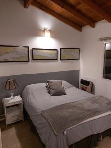 um quarto com uma cama e três fotografias na parede em Alarken em Ushuaia