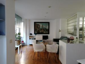 Una sala de estar con una mesa y sillas blancas. en Casana4, en Tudela