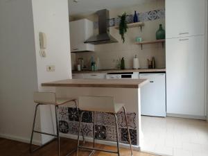 Una cocina con una encimera y dos taburetes en ella. en Casana4, en Tudela 4 fotos más