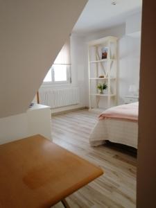 Un dormitorio blanco con una cama y una mesa. en Casana4, en Tudela