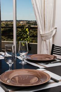 a table with two plates and wine glasses on it at Quennet in Carrières-sous-Poissy