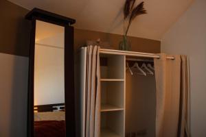 a mirror in a bedroom with a closet with a curtain at Quennet in Carrières-sous-Poissy