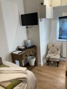 a bedroom with a bed and a desk and a chair at Linnaea Rooms - Corston Nr Malmesbury in Malmesbury