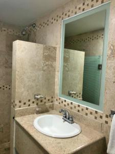 een badkamer met een wastafel en een spiegel bij Hotel Ruah in Cuernavaca