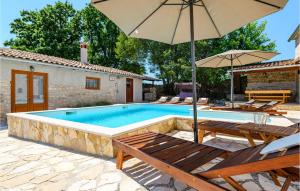 a swimming pool with two chairs and an umbrella at Holiday Home Rezanci 05 in Režanci