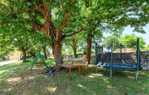 a park with a tree and a swing at Holiday Home Rezanci 05 in Režanci