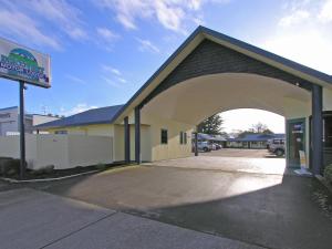 a building with an archway in a parking lot at Discovery Motor Lodge in Masterton