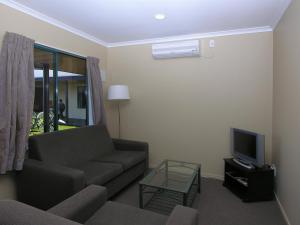 a living room with a couch and a tv at Discovery Motor Lodge in Masterton