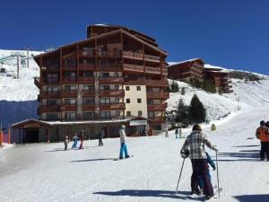 a group of people skiing in front of a ski lodge at 3 pièces cosy, 6 pers, pied des pistes exposé sud, Les Menuires - FR-1-178-365 in Les Bruyères