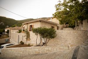 een huis met een stenen muur en een boom bij Casa de la Vita in Katochorion