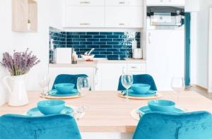 uma sala de jantar com uma mesa com cadeiras azuis em 365Balaton Apartmanok em Alsóörs