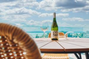 a bottle of wine sitting on a table with a glass at 365Balaton Apartmanok in Alsóörs