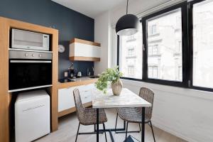 a kitchen with a table with chairs and a microwave at Edificio Remodelado. Frente al Munal. Centro Histórico in Mexico City