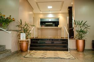 a lobby with stairs and potted plants and a mirror at Hotel Girardelli in Araras
