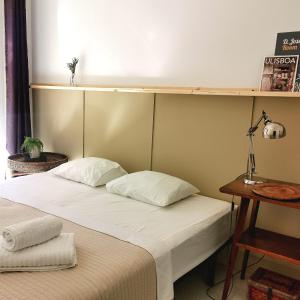 łóżko z 2 poduszkami w pokoju w obiekcie Ey Lisbon GuestHouse w Lizbonie