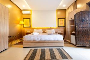 a bedroom with a large bed and yellow walls at The Lemonary Marrakech in Marrakech