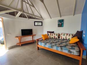 sala de estar con sofá y TV en TAHITI - Taharaa Beach Bungalow en Arue