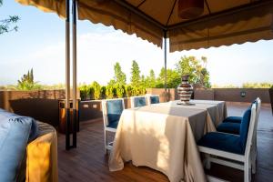 a table and chairs under an umbrella on a patio at The Lemonary Marrakech in Marrakech