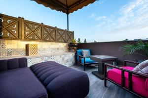 a patio with a couch and a table and chairs at The Lemonary Marrakech in Marrakech