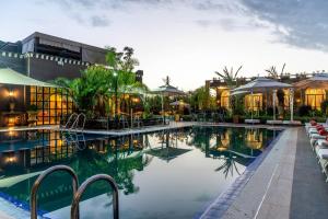 a swimming pool with tables and chairs next to a building at The Lemonary Marrakech in Marrakech