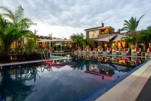 un complexe avec une piscine entourée de chaises et un bâtiment dans l'établissement The Lemonary Marrakech, à Marrakech