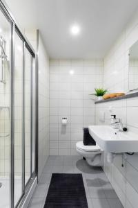 a white bathroom with a sink and a toilet at Green Stay in Essen