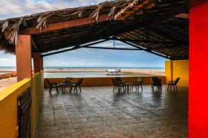 a patio with chairs and a table and a beach at Pousada Escape in Barra Nova