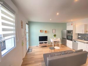 sala de estar con sofá y cocina en Le Rémois - PARKING - Cour privative - WIFI, en Reims