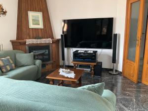 a living room with a tv and a couch and a table at Tuscany Hills Penthouse in Fivizzano