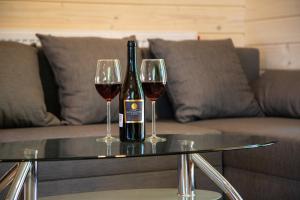 a bottle of wine and two glasses on a table at Domki Krynica in Krynica Zdrój