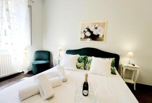 Un dormitorio con una cama blanca con una botella de vino. en BBHOME Saint Paul design boutique Apartment en Roma