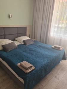 a bedroom with a blue bed with towels on it at Pokój 31 Domino Family Dominikana in Sianozety
