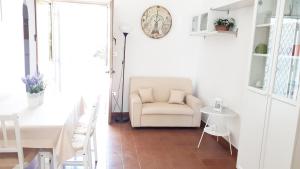 Una sala de estar con una silla y una mesa. en Villa gli Ulivi con ampio giardino ed ogni comfort a pochi passi dal mare vicino Gallipoli, en Torre Suda